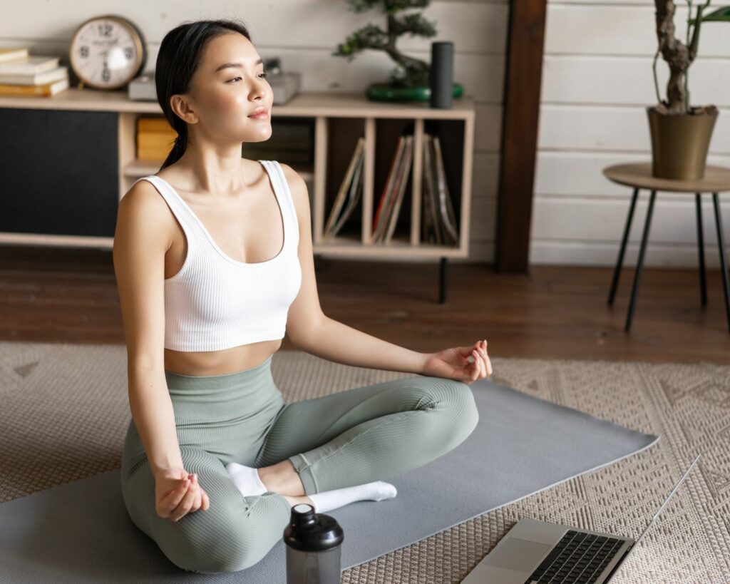 Jeune femme assise en tailleur sur un tapis