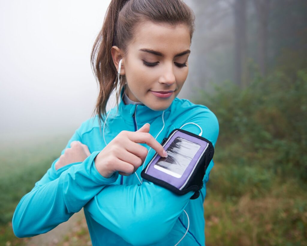 Jeune femme qui regarde son application de sport pendant sa séance de course