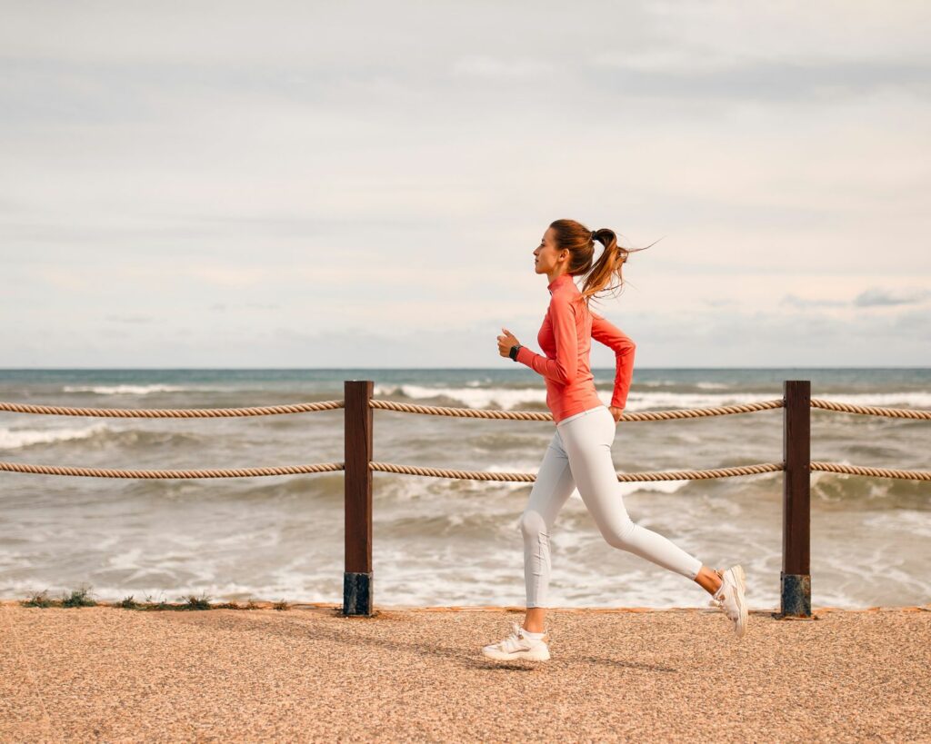 Jeune femme qui court au bord de la plage