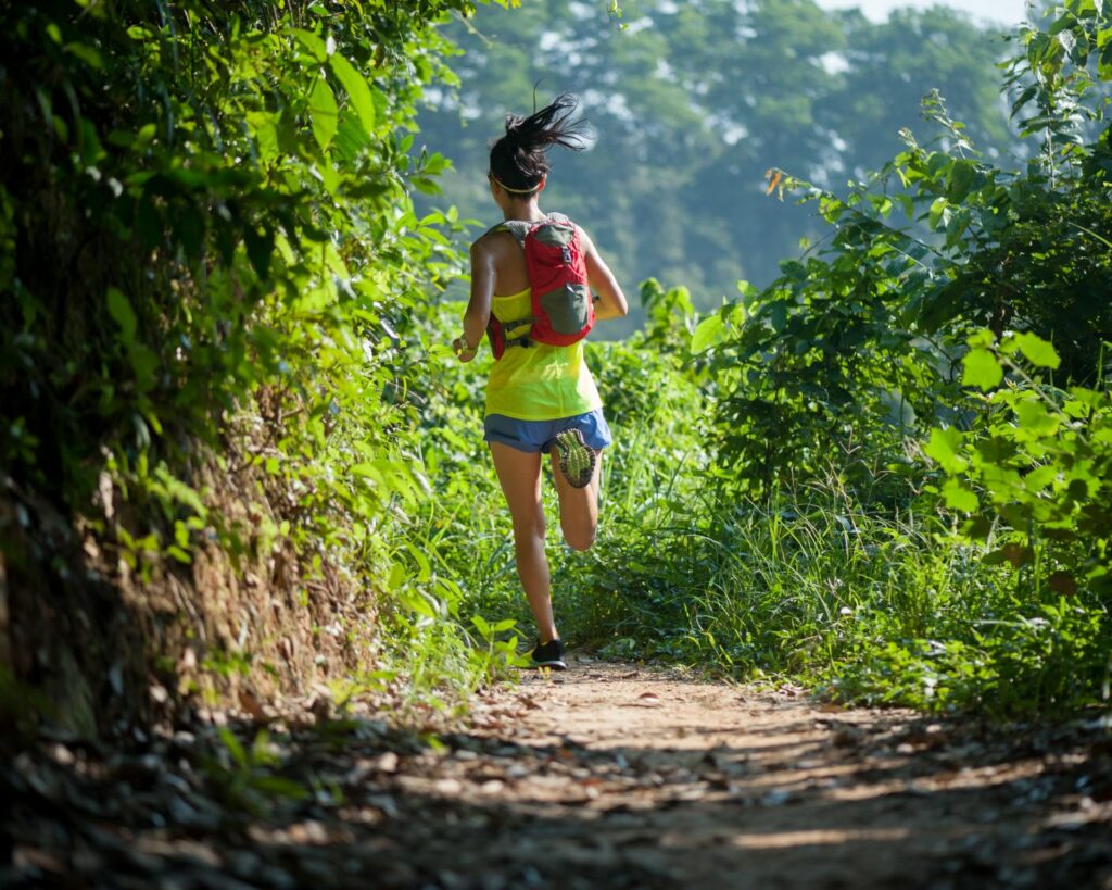 Jeune femme de dos qui fait un trail