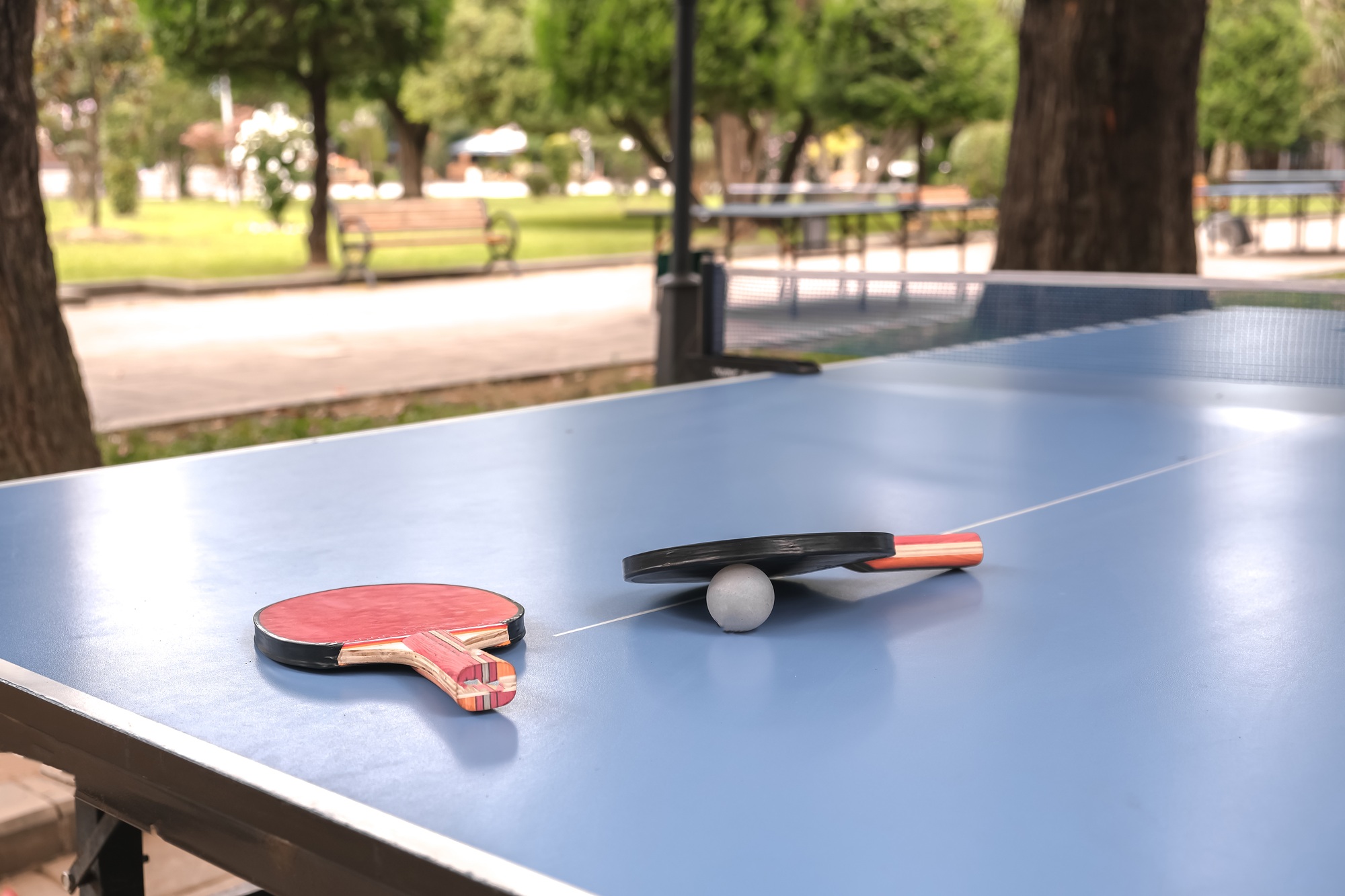 table for ping-pong, rackets, a ball for table tennis lie on the table. Street activity, hlbbi